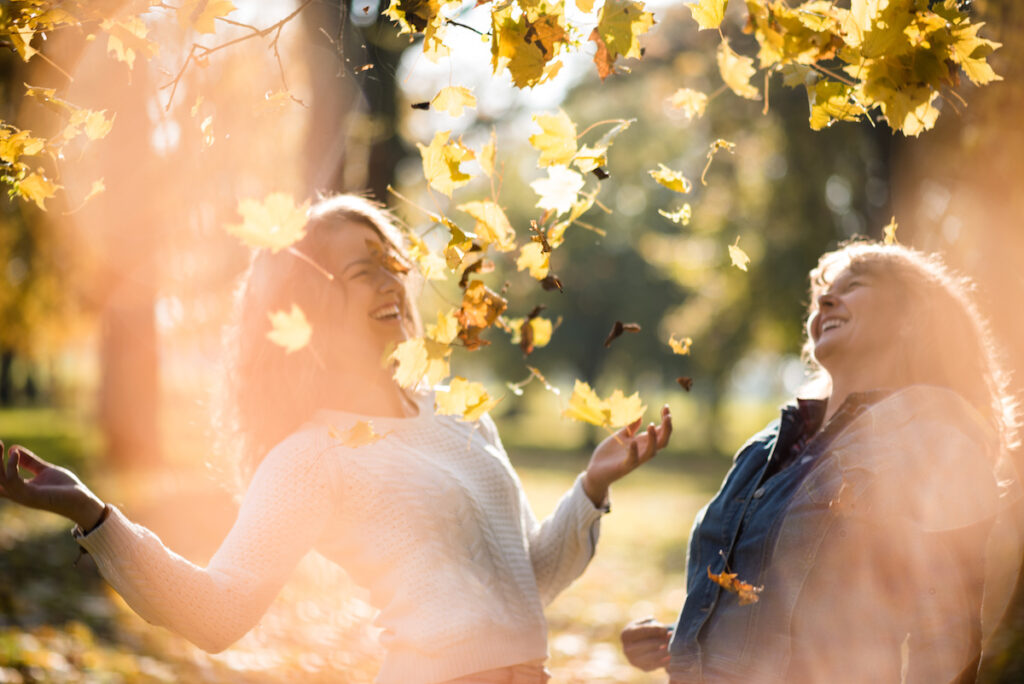 women enjoying fall leaves
